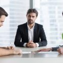 spouses couple signing decree papers getting divorced in lawyers office