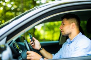 man driving and looking message in his smart phone