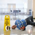 hispanic worker falling on wet floor crying in pain